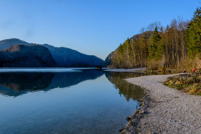 Scenic view of lake and mountains against blue sky