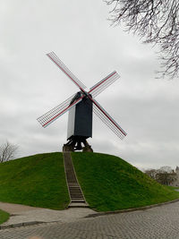 Traditional windmill on field against sky