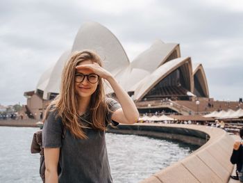 Portrait of smiling woman standing in city