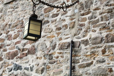 Low angle view of an historical electric lamp hanging on a building