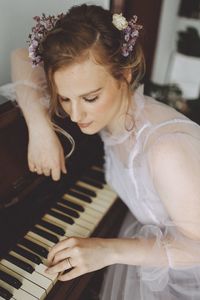 Midsection of woman playing piano at home