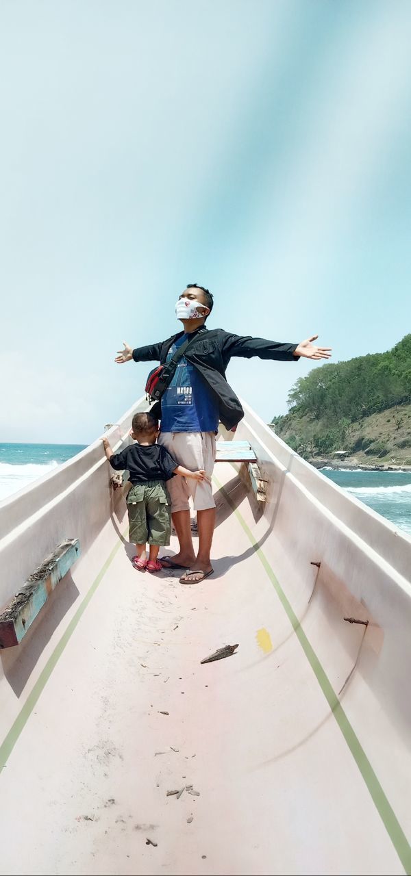 YOUNG WOMAN ON BOAT AGAINST SKY