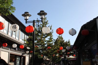 Low angle view of lanterns hanging on street against sky