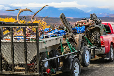 Car carrying garbage on road against sky