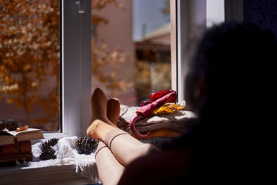 Rear view of woman sitting by window