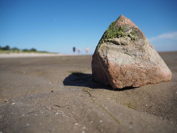 Close-up of rock on land against sky