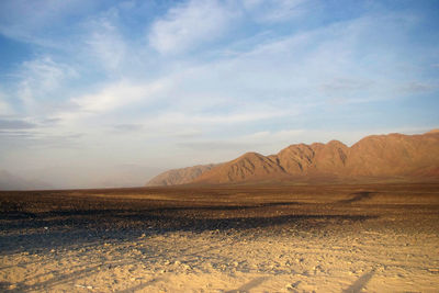 Scenic view of desert against sky in golden hour