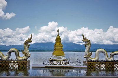 Sculpture of building against cloudy sky