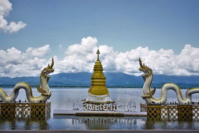 Sculpture of building against cloudy sky