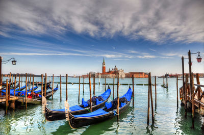 Boats moored on wooden post in water