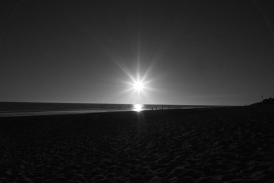 Scenic view of sea against bright sun