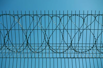 Low angle view of barbed wire against clear sky