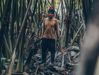 Portrait of man standing amidst plants