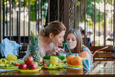 Girl looking away while sitting on table