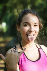 Portrait of teenage girl gesturing while standing at park