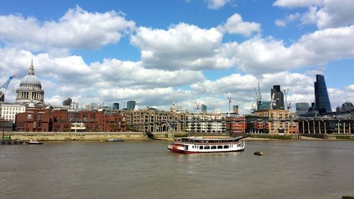 Boats in river with city in background