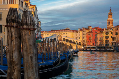 Boats moored at canal against buildings in city