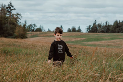 Portrait of woman standing on field against sky