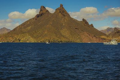 Scenic view of sea and mountains against sky