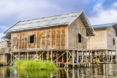 Exterior of house by lake against sky