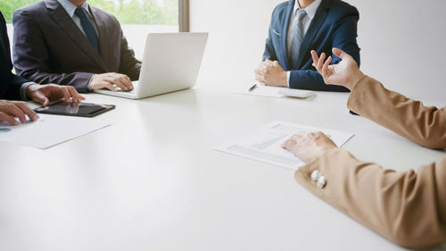 Midsection of man using laptop on table