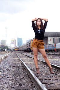 Portrait of fashionable woman standing on railroad track
