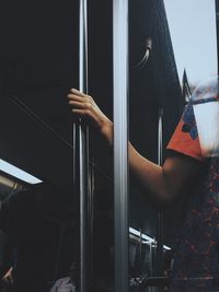 Cropped hand holding pole in bus