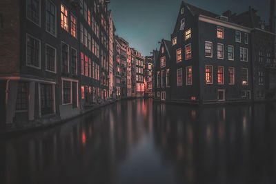Reflection of buildings on canal at night