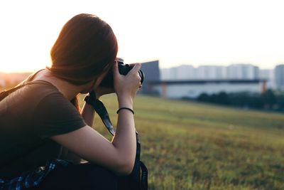 Woman photographing at sunset