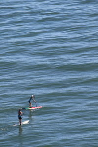 High angle view of people paddleboarding on sea