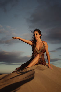 Woman sitting in a sea against sky