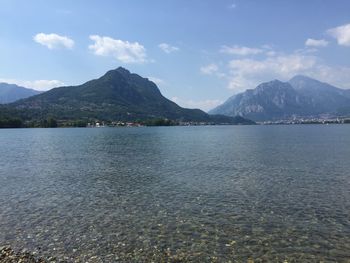 Scenic view of lake by mountains against sky