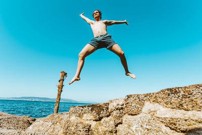 Full length of woman jumping on beach