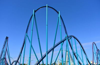 Low angle view of ferris wheel against blue sky