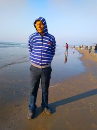 Full length of man standing on beach against sky