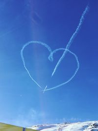 Heart shape of vapor trails in blue sky