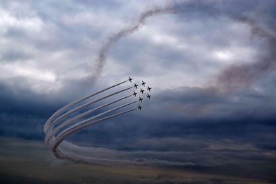Low angle view of aircrafts performing in storm clouds