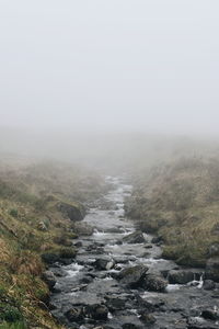 Scenic view of landscape against sky during foggy weather