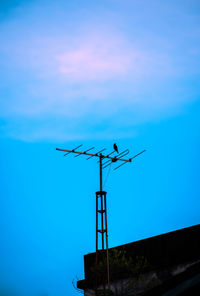 Low angle view of weather vane against sky