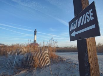 Lighthouse sign on wooden post