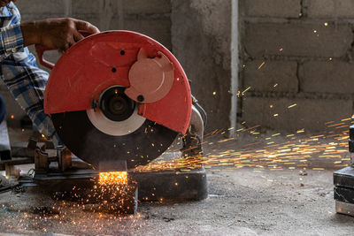 Low section of man cutting metal