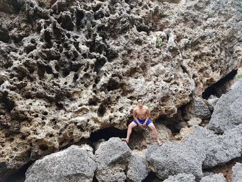 Full length of girl sitting on rock