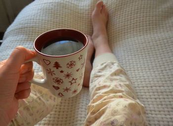 Low section of woman holding coffee cup