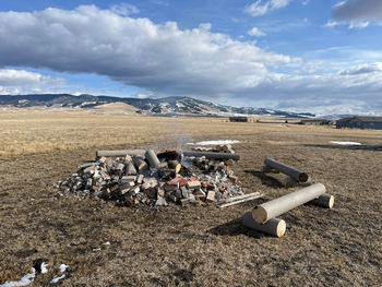 Garbage on field by mountains against sky