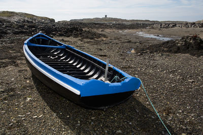 Boat on landscape against blue sky