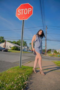 Low section of woman with text on road against sky