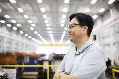Smiling supervisor standing in steel industry factory