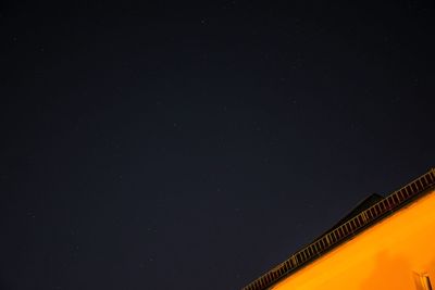 Low angle view of illuminated building against clear sky at night