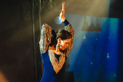 Close-up of young woman standing against wall