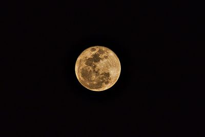 Low angle view of full moon against clear sky at night